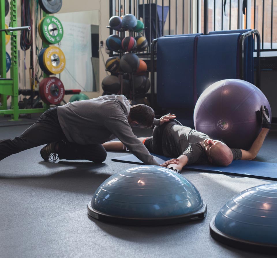 Smugmug employees stretching together in a gym after a workout 