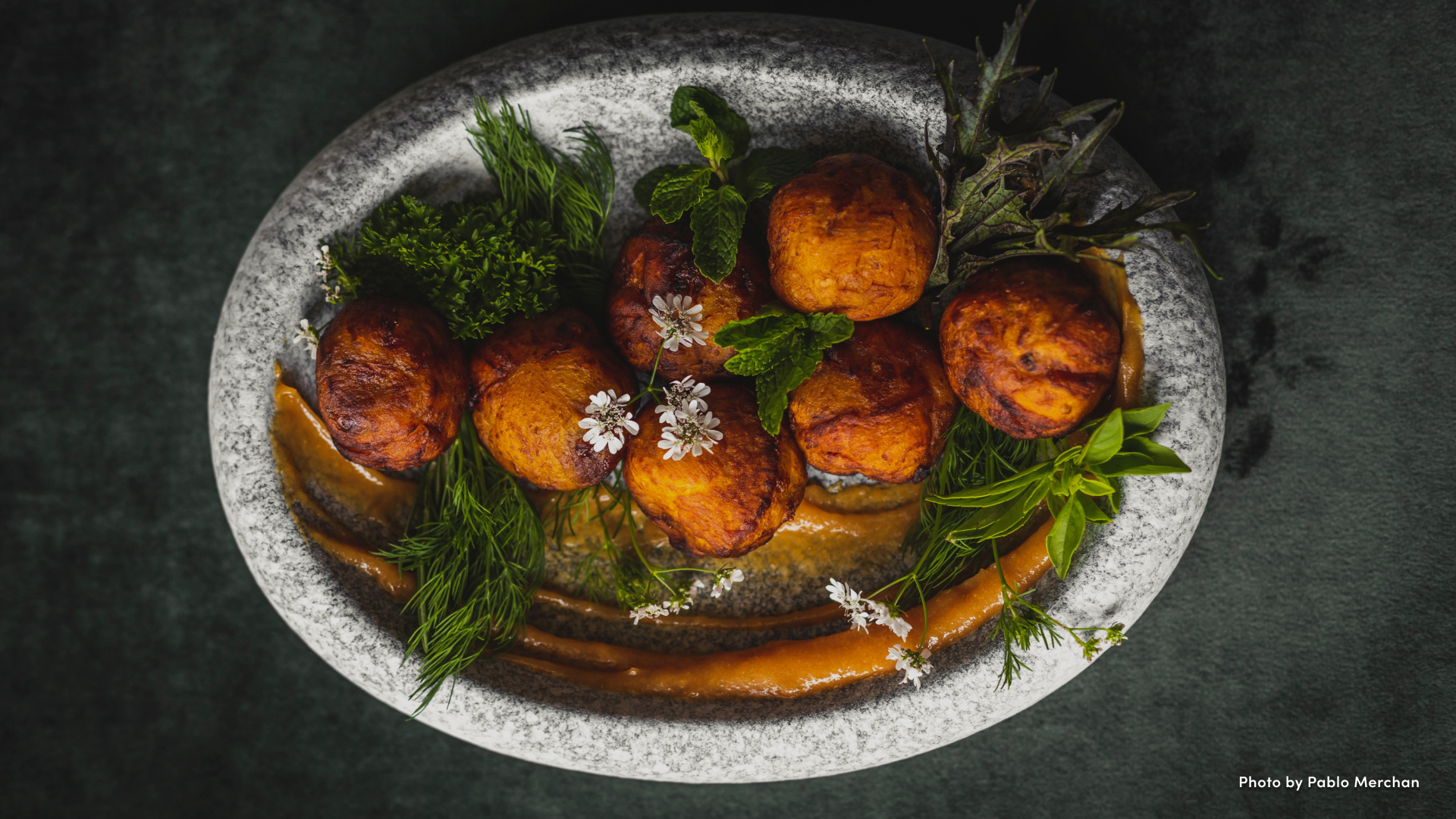 Overhead view of falafel surrounded by fresh greens on a platter.
