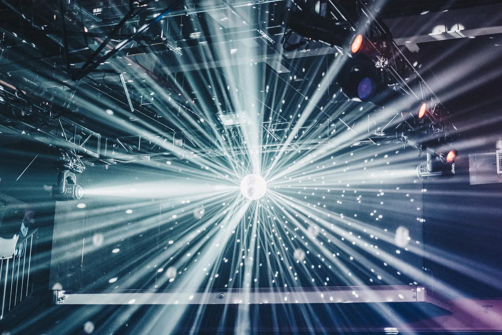 A long-exposure zoom photo of a mirrorball reflecting theatre lights.